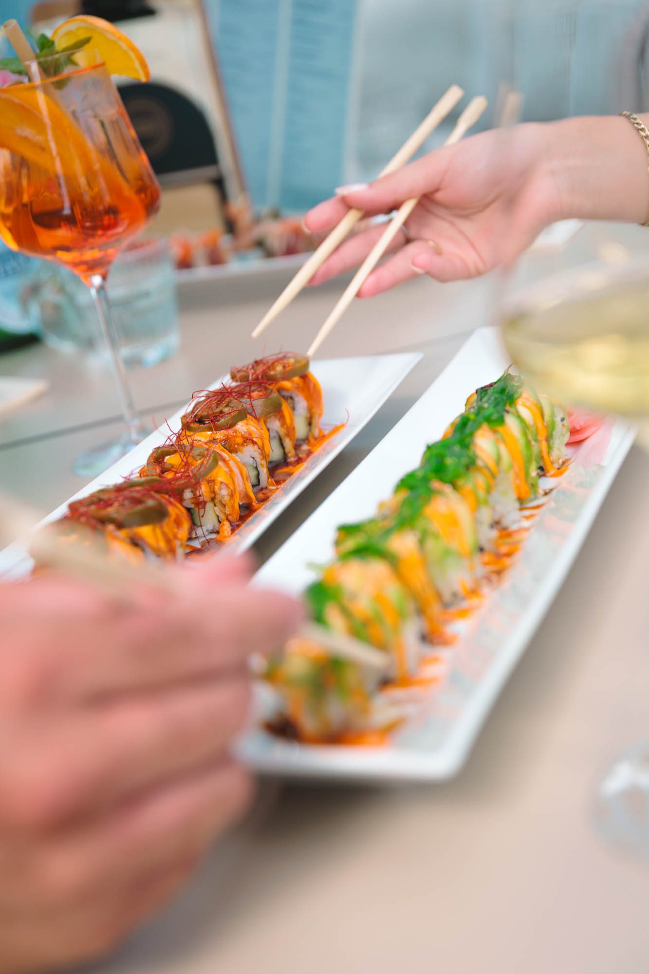 Gasten delen sushi aan tafel bij atMirror