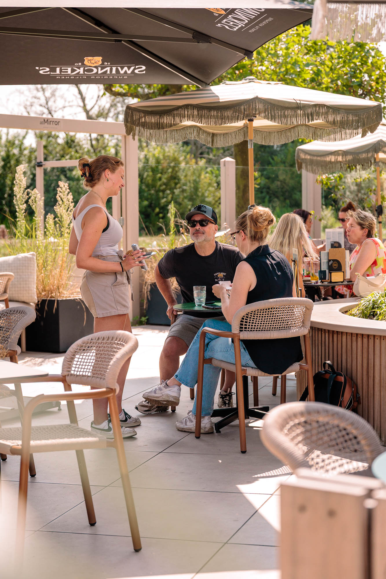 Gezelschap onder de parasol op het terras van atMirror